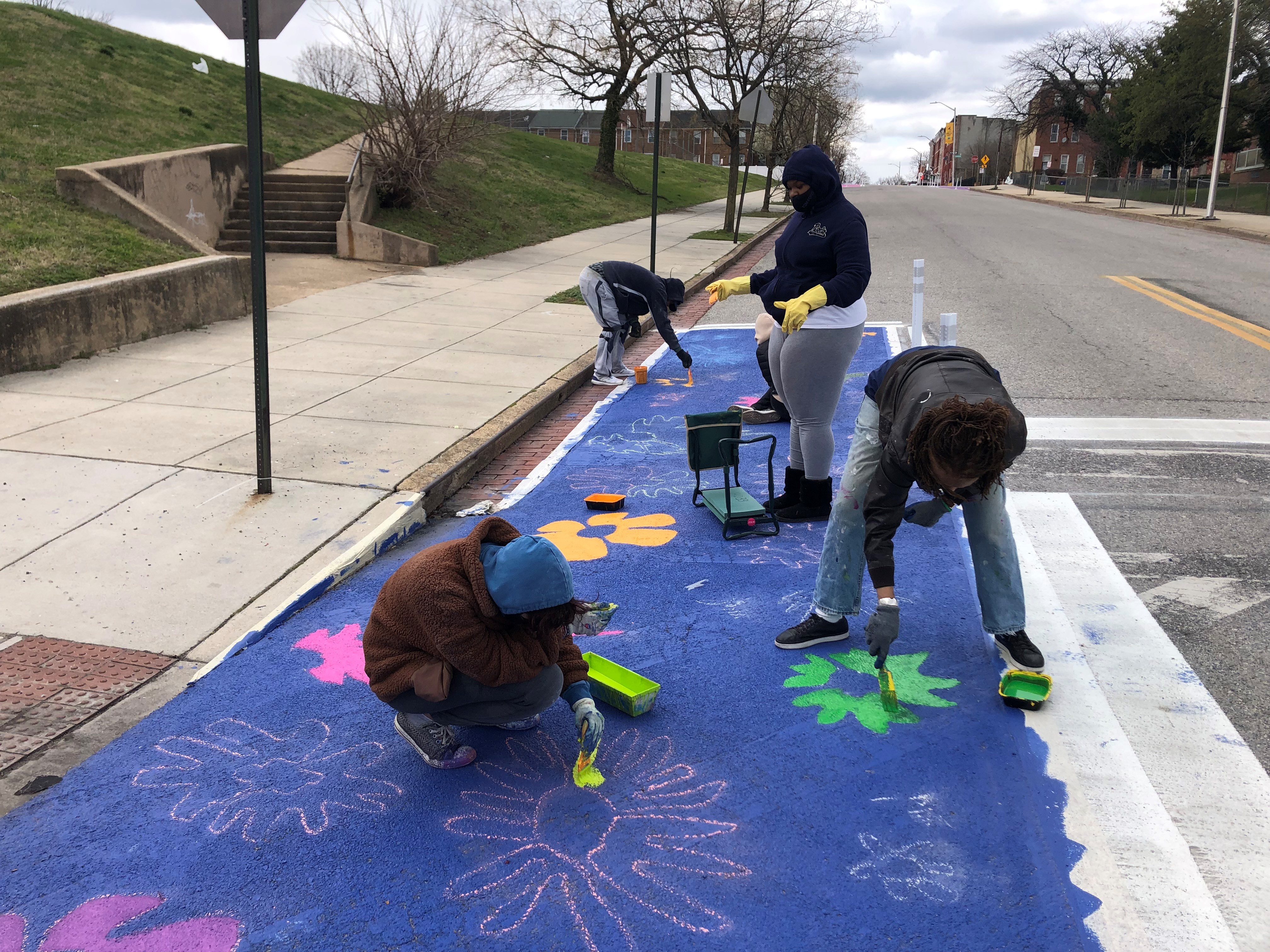 Residents painting art in the right-of-way at Johnston Square.